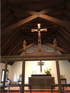 Chapel at Adelynrood, showing rood screen sculpture depicting two women watching near Christ on the cross